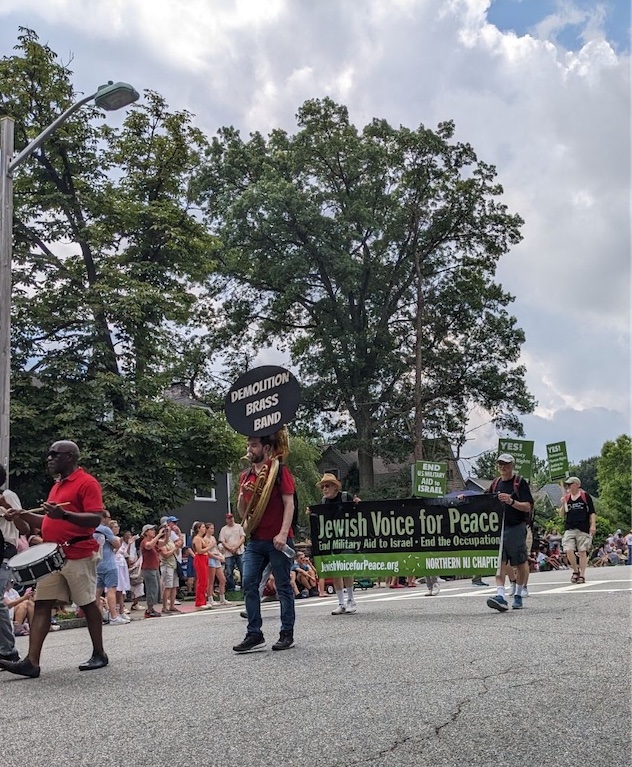 NNJ JVP Banner carried in parade behind Demolition Brass Band