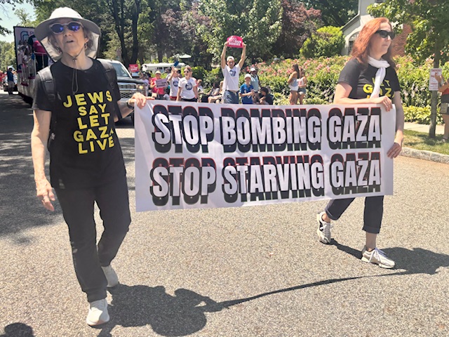 JVPers in “Jews Say Let Gaza Live” T-shirts carry a banner saying “Stop Bombing Gaza • Stop Starving Gaza”, another group marches behind them.