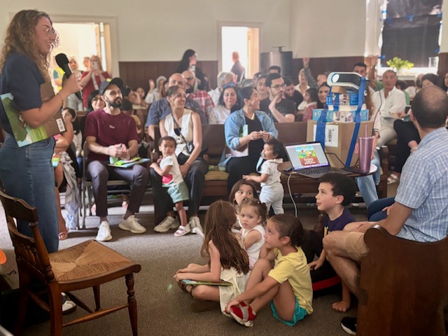 Author Jenan A. MatarI talks to a roomful of children and adults at substitute book-reading event.
